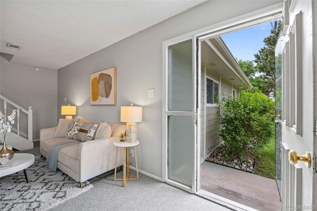1250 S Monaco Pkwy Unit 50, Denver, CO 80224 - living room with carpet floors, stairway, and a textured ceiling
