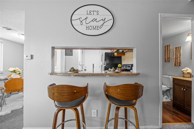 1250 S Monaco Pkwy Unit 50, Denver, CO 80224 - kitchen with freestanding refrigerator and a breakfast bar