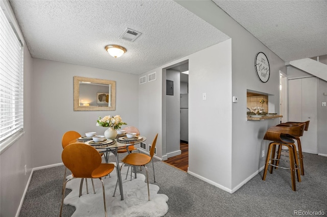1250 S Monaco Pkwy Unit 50, Denver, CO 80224 - carpeted dining room featuring a textured ceiling and plenty of natural light