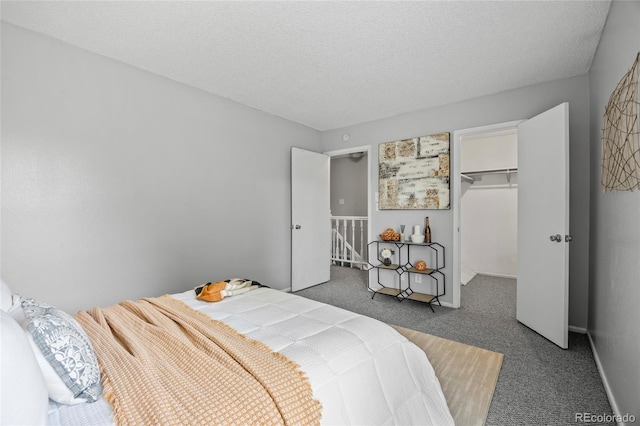 1250 S Monaco Pkwy Unit 50, Denver, CO 80224 - carpeted bedroom featuring a walk in closet, a closet, and a textured ceiling