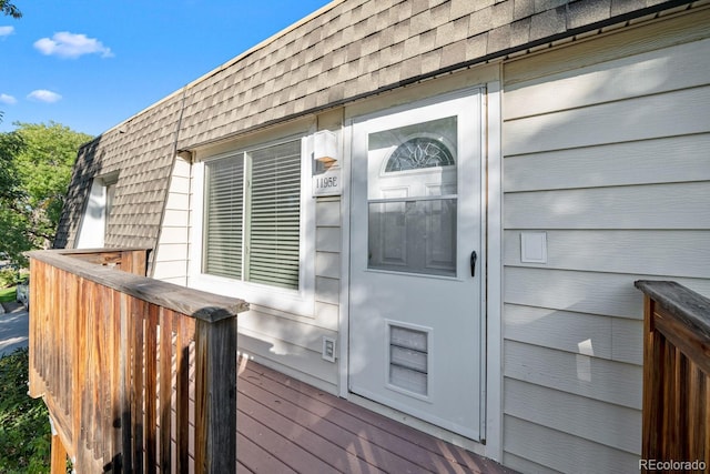 1195 S Oneida St Unit E, Denver, CO 80224 - view of exterior entry with a shingled roof