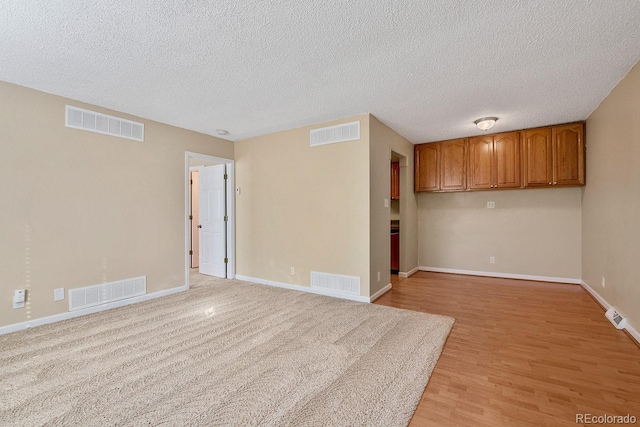 1195 S Oneida St Unit E, Denver, CO 80224 - spare room with light wood-style floors and a textured ceiling