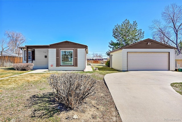 view of front of house with a detached garage, an outbuilding, a front yard, and fence