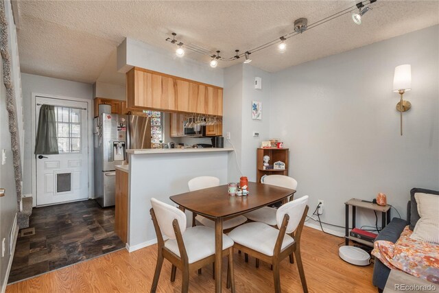 dining area with wood finished floors and a textured ceiling