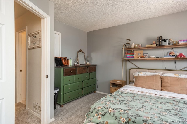 carpeted bedroom with visible vents, baseboards, and a textured ceiling