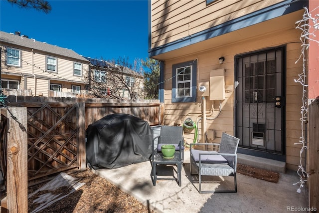 view of patio with area for grilling and fence