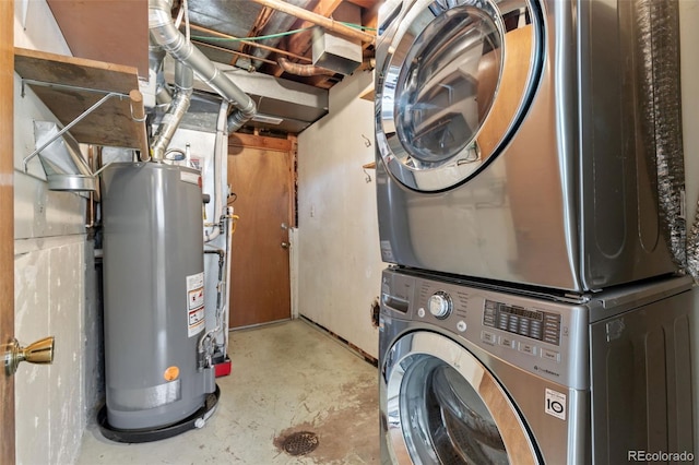 clothes washing area featuring stacked washing maching and dryer and water heater