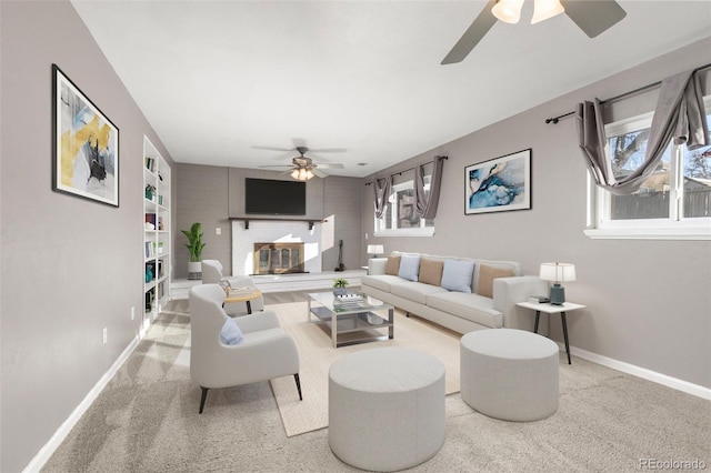 carpeted living room featuring ceiling fan, built in features, and a fireplace