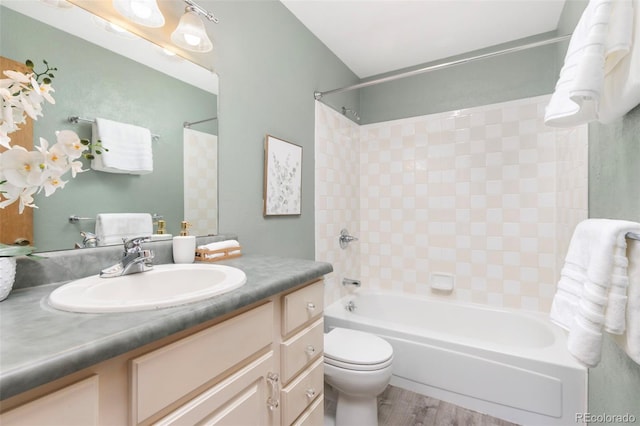 bathroom featuring toilet, vanity, shower / tub combination, and wood finished floors