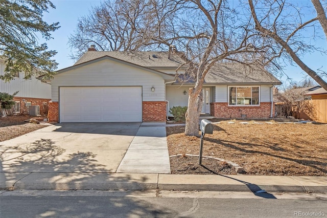 view of front of property featuring a garage, concrete driveway, and brick siding