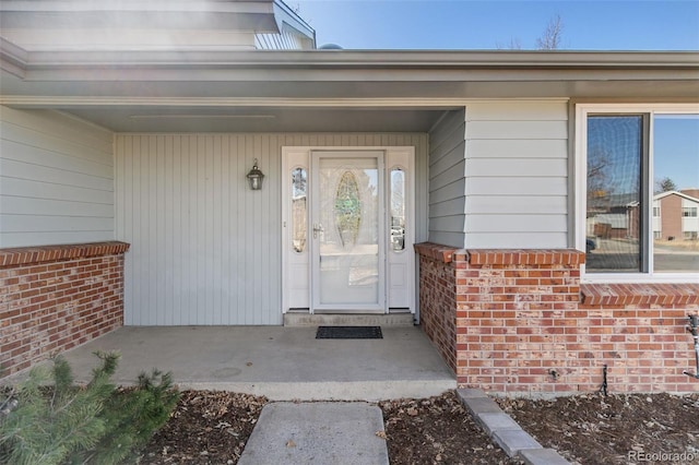 entrance to property featuring brick siding