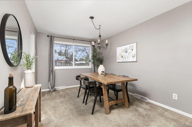 carpeted dining area featuring an inviting chandelier, baseboards, and visible vents