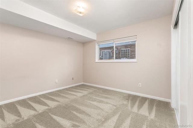 carpeted spare room with visible vents and baseboards