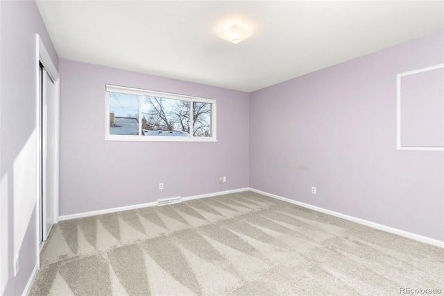 unfurnished bedroom featuring a closet, visible vents, light carpet, and baseboards