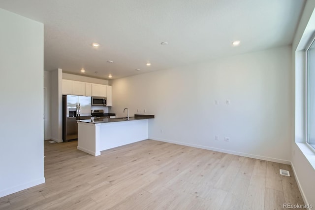 14578 W 90th Ln Unit B, Arvada, CO 80005 - kitchen with stainless steel appliances, dark countertops, light wood-style flooring, white cabinetry, and recessed lighting