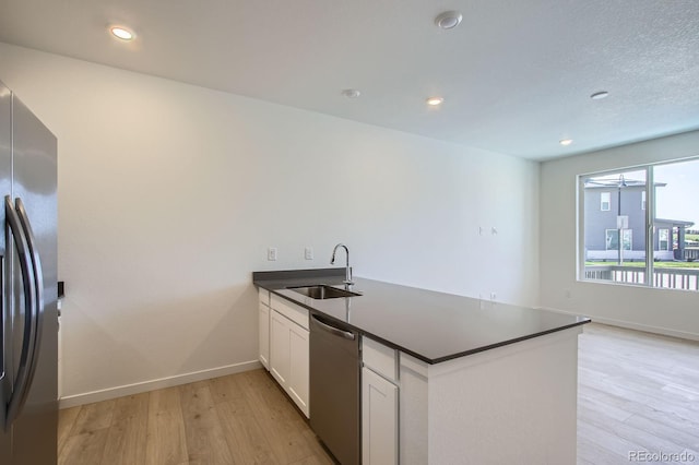 14578 W 90th Ln Unit B, Arvada, CO 80005 - kitchen featuring appliances with stainless steel finishes, dark countertops, a peninsula, light wood-style floors, and white cabinets