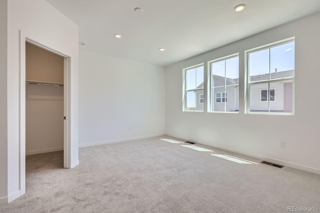 742 N Bently St, Watkins, CO 80137 - unfurnished bedroom with multiple windows, carpet flooring, a walk in closet, recessed lighting, and a closet