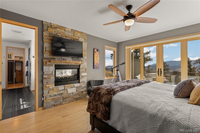 15077 Wilson Peak Rd, Pine, CO 80470 - bedroom with access to outside, a stone fireplace, french doors, wood finished floors, and ceiling fan