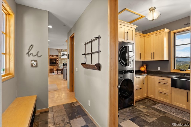 15077 Wilson Peak Rd, Pine, CO 80470 - laundry room featuring stacked washing machine and dryer, stone tile flooring, recessed lighting, and a stone fireplace