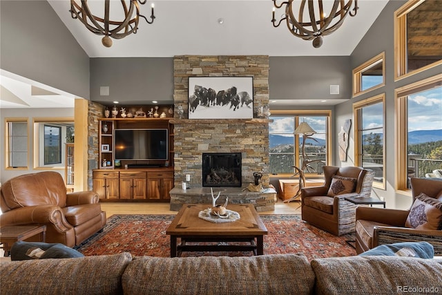 15077 Wilson Peak Rd, Pine, CO 80470 - living area featuring a chandelier, high vaulted ceiling, wood finished floors, and a stone fireplace