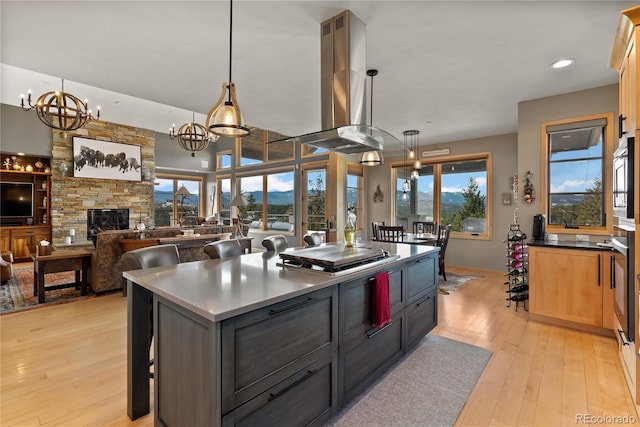 15077 Wilson Peak Rd, Pine, CO 80470 - kitchen featuring light wood finished floors, a kitchen island, a chandelier, a breakfast bar area, and decorative light fixtures