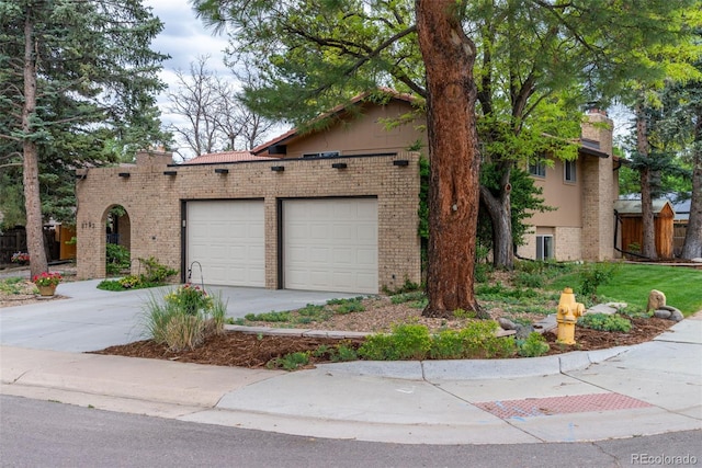 8793 E Monmouth Pl, Denver, CO 80237 - view of front of house featuring driveway, brick siding, and a garage