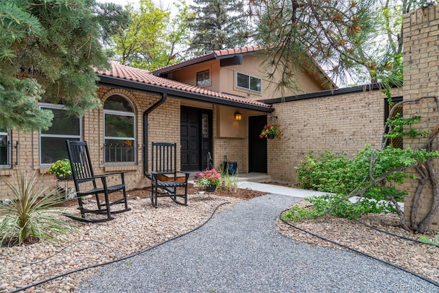 8793 E Monmouth Pl, Denver, CO 80237 - rear view of property with a tile roof, brick siding, and stucco siding