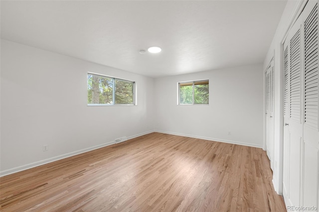 8793 E Monmouth Pl, Denver, CO 80237 - unfurnished bedroom with baseboards, light wood-style floors, and multiple closets
