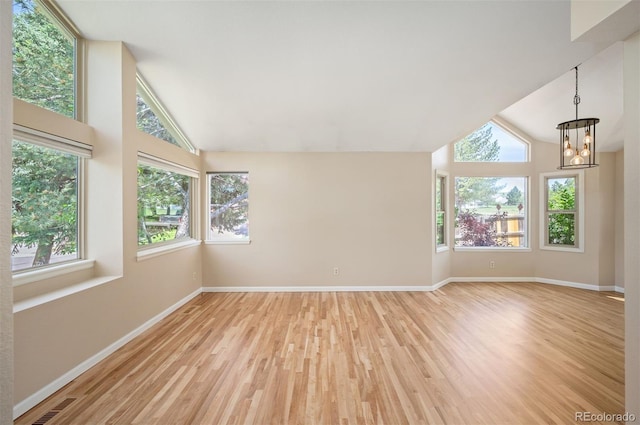 7582 Powderhorn Dr, Lone Tree, CO 80124 - unfurnished living room featuring a chandelier, wood finished floors, baseboards, and high vaulted ceiling