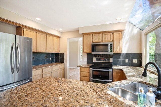 7582 Powderhorn Dr, Lone Tree, CO 80124 - kitchen with stainless steel appliances, a sink, light brown cabinets, light stone countertops, and tasteful backsplash