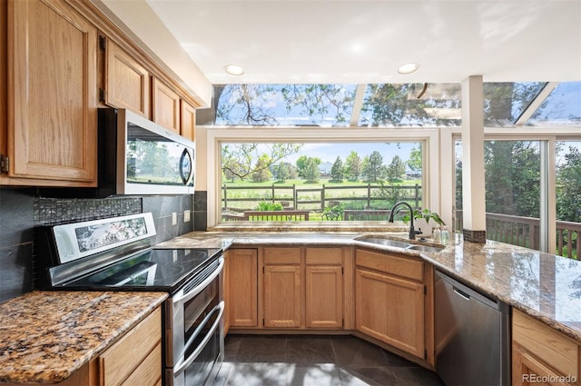 7582 Powderhorn Dr, Lone Tree, CO 80124 - kitchen with stainless steel appliances, a sink, backsplash, light stone counters, and dark tile patterned flooring