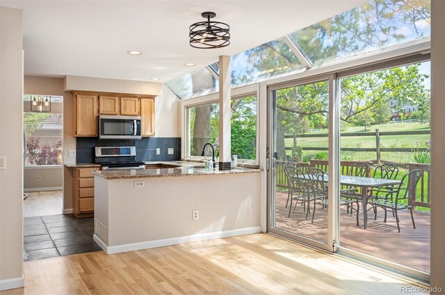 7582 Powderhorn Dr, Lone Tree, CO 80124 - kitchen with stainless steel appliances, light wood-style floors, plenty of natural light, backsplash, and recessed lighting