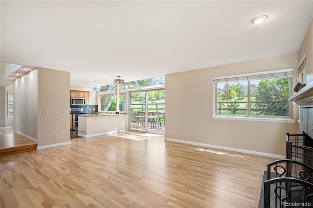 7582 Powderhorn Dr, Lone Tree, CO 80124 - unfurnished living room with a fireplace, light wood-type flooring, and plenty of natural light