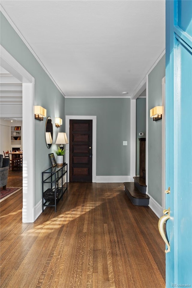 foyer with ornamental molding, wood finished floors, and baseboards