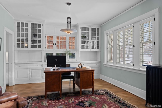 office space with crown molding, baseboards, and wood finished floors