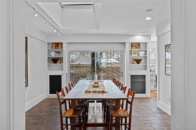 dining area with built in shelves, recessed lighting, rail lighting, and baseboards