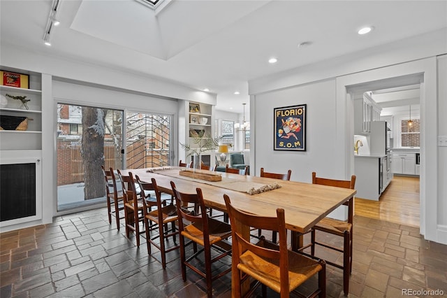 dining area with an inviting chandelier, stone tile flooring, and recessed lighting