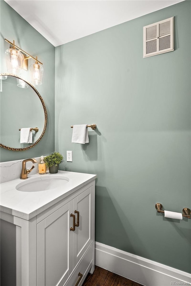 bathroom featuring wood finished floors, vanity, visible vents, and baseboards