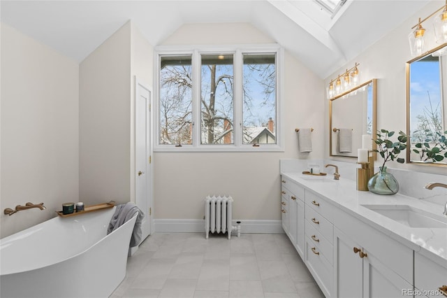 bathroom with vaulted ceiling with skylight, radiator, a sink, and double vanity