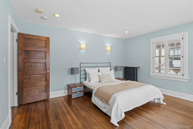 bedroom with baseboards, wood finished floors, and recessed lighting