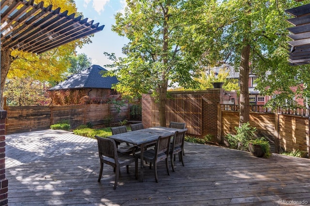 wooden terrace with outdoor dining space, a pergola, and fence private yard