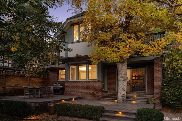 exterior space featuring brick siding and a wooden deck