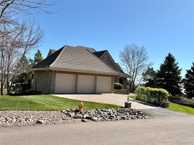 exterior space featuring an attached garage, a yard, and driveway