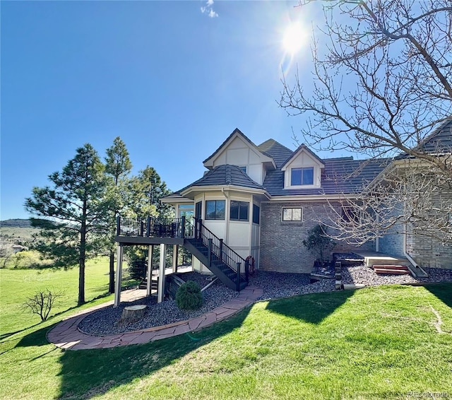 back of property with stairway, a yard, and a wooden deck
