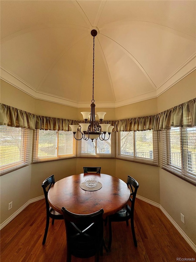 dining area with baseboards, an inviting chandelier, wood finished floors, and lofted ceiling