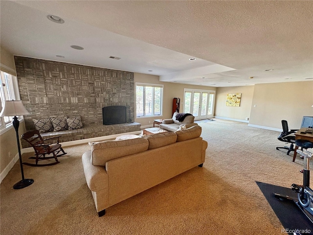 carpeted living room with baseboards, recessed lighting, a textured ceiling, and visible vents