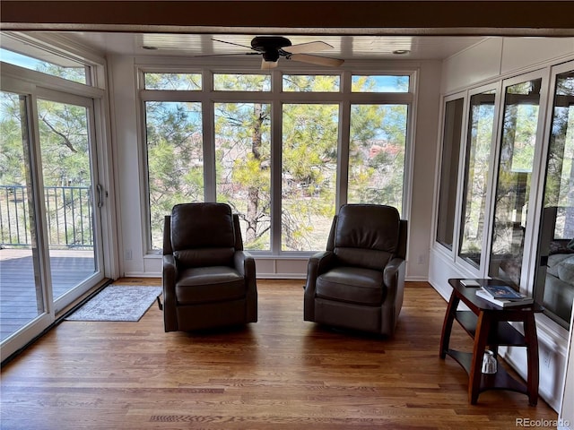 sunroom with a wooden deck, a wealth of natural light, and wood finished floors