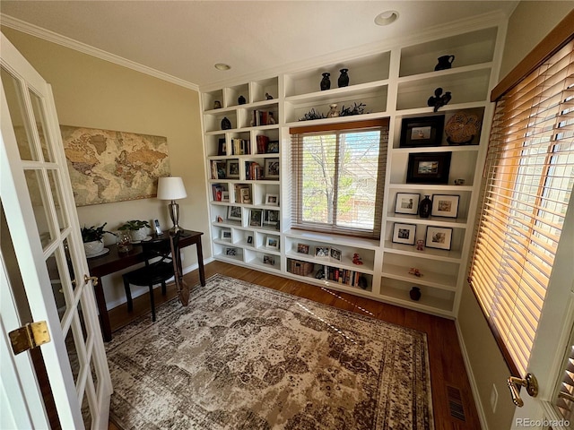 home office with visible vents, ornamental molding, and wood finished floors