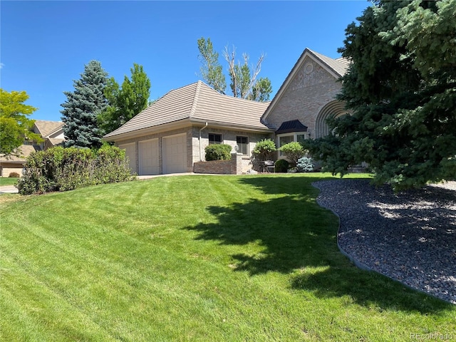 view of front of home with an attached garage, stone siding, and a front yard