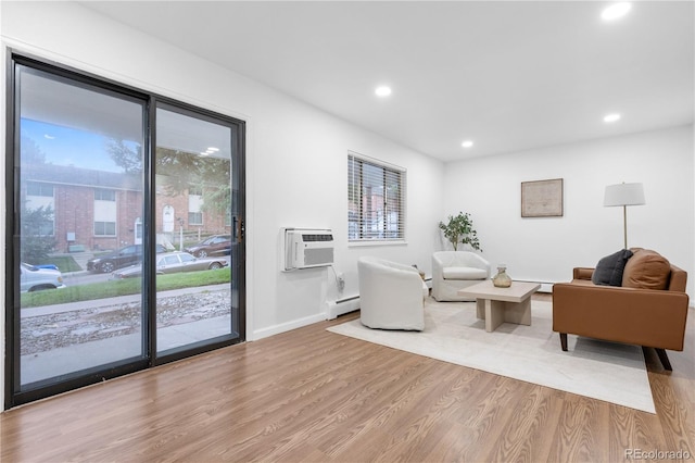 living room with light wood-type flooring, baseboard heating, and an AC wall unit